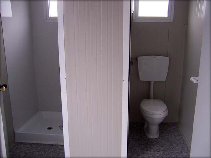 Cabine sanitária com sanita separada e chuveiro independente