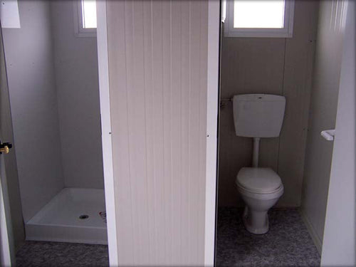 Cabine sanitária com sanita separada e chuveiro independente