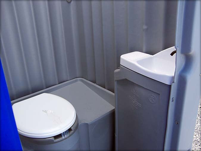 Cabina sanitária pequena com chuveiro e sanita